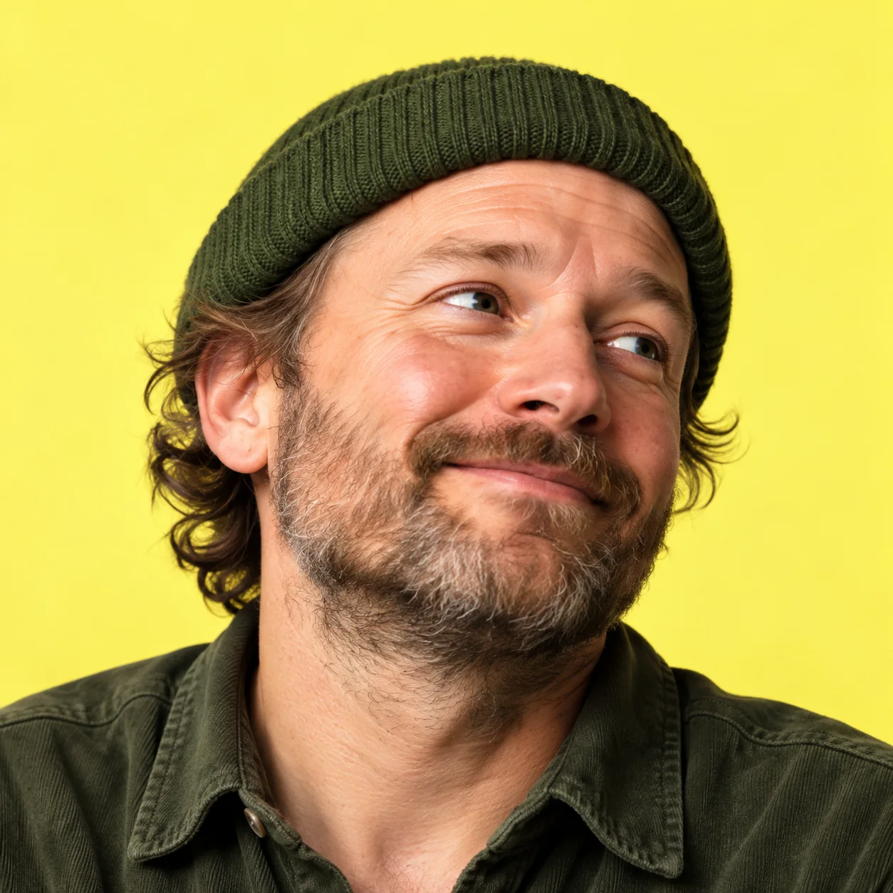 Drew, wearing a green beanie, with a thoughtful smile.